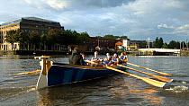 Bristol Pilot Gig Club's Ladies crew practicing in their gig "Isambard" on Bristol Floating Harbour, with Arnolfini and city skyline in background. England, UK. July 2008, Model Released