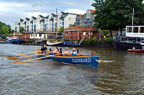 Bristol Pilot Gig Club's Ladies crew practicing in their gig "Isambard" on Bristol Floating Harbour, with city skyline in background. England, UK. July 2008, Model Released
