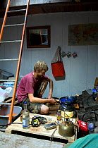 Man preparing food in hull of traditional Danish Fishing boat, Bristol Floating Harbour, UK. July 2008, Model Released