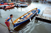Crew of Bristol Pilot Gig Club manoeuvering gig "Isambard" alongside pontoon, Bristol Floating Harbour, UK. July 2008, Model Released