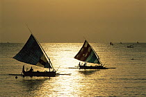 Fishing boats return to shore at dawn after night fishing, Tulamben Bay, Bali, Indonesia, model released