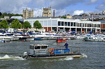 A maintainance barge working at the Bristol Harbour Festival, August 2008, with Bristol Ferryboat in the background and city skyline with Cathedral