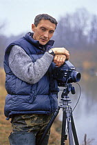 Igor Shpilenok, photographer and nature conservationist, with camera beside river, Bryansky Les Zapovednik, Bryansk province, Russia
