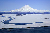 Snow-covered Kronotsky volcano connected to the Pacific Coast by the Kronotskaya river, Kronotsky Zapovednik, Kamchatka, Far East Russia
