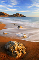 Tide coming in over sandy beach and rocks, Worbarrow Bay, Dorset, UK. February 2008.