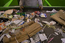 Rubbish passes along a conveyor belt to be sorted  for recycling by hand, Arles, Provence, France