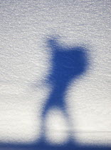 Silhouette of hiker with backpack against snow, Norway. April