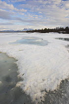 Late spring meltdown of ice on lake Fjellfroskvann in Troms, Northern Norway. Rostafjellet Mountain is in the background. May