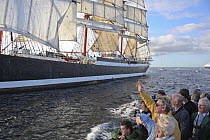 Spectators aboard "Enterprise" waving to the crew of barque "Sedov" at the Funchal 500 Tall Ships Regatta race day, Saturday 13th September 2008. Falmouth, Cornwall, UK