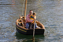 Father teaching son how to scull at the Douarnenez Maritime Festival, France, July 2008
