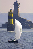 Sloop sailing past marker and lighthouse at Pointe du Raz, during the Tour de Bretagne, 2001