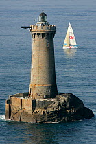 Figaro yacht passing Phare du Four lighthouse, during Tour de Bretagne (Round Brittany Race), September 2005