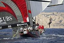 Crew member swinging from yard arm on Team Alinghi yacht, America's Cup Louis Vuitton Act 1, Marseille, France 2004