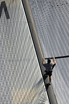 Crew member walking up mast on Team Alinghi yacht, America's Cup Louis Vuitton Act 1, Marseille, France 2004