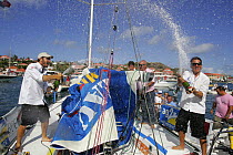 Skipper Eric Peron and co-skipper Miguel Danet celebrating with champagne after Transatlantic AG2R race, 2008. St Barths, May 2008