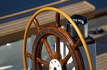 Wooden steering wheel and compass upon yacht