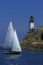 Sloop sailing past lighthouse, L'ille Louet, Bay of Morlaix, Finistere, Brittany, France