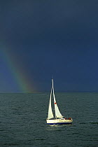 Glenan 33ft yacht and rainbow with stormy skies, Concarneau, Brittany, France, February 2002