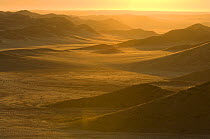 Rolling hills and mountains at sunrise, Skeleton Coast Park, Namibia. July 2008.