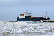 Container ship entering port during storm, North Sea, Ostend, Belgium. March 2008.