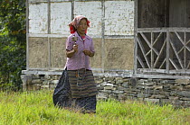 Woman holding prayer wheel in Tashiding Monastery, Sikkim, India October 2007