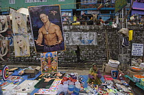 Woman selling pop posters and other goods at street market stall, Sombare, West Sikkim, India October 2007
