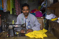 Tailor with sewing maching in the street market of Sombare, West Sikkim, India October 2007