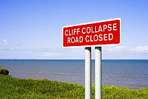 Warning sign for Road closure due to coastal erosion undermining the cliff, Yorkshire, UK