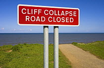 Warning sign for Road closure due to coastal erosion undermining the cliff, Yorkshire, UK