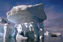 Tourists in Zodiak boat view interesting shaped icebergs, Antarctica 2008