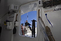 Skipper Armel le Cleac'h at the helm, seen from within the cabin of Monohull Imoca 60ft "Brit Air", Concarneau, Brittany, France. April 2008