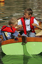Two young boys rowing a pram boat, Douarnenez Maritime Festival, France 2004
