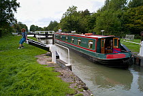 Narrow boat leaving a lock on the Kennet and Avon canal at Caen Hill, Wiltshire. September 2008