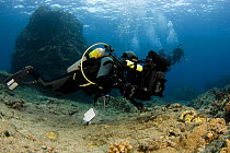 Scott Blain lines up on a reef with his HD video camera in a Gates housing. Kona Coast, Hawaii. Model Released