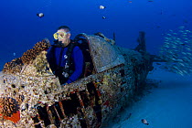 Diver (MR) in the cockpit of a wreck of a WW II Corsair fighter plane off South-East Oahu, Hawaii. July 2007. Model released