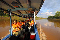 Tourists on boat travelling along the Tambopata river, Tambopata National Reserve, Amazonia, Peru