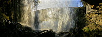 View from behind the waterfall of a curtain of water falling, Thornton Force, Yorkshire, UK