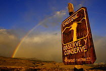 Rainbow over the patagonian steppe and a sign ^Watch and preserve^ for the protection of Darwin's Rhea or Choique (Pterocnemis pennata) near El Chalten, Los Glaciares National Park, Patagonia, Argenti...