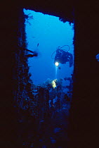 Diver explores wreck of 'The Santa', scuttled in July 1988 and now an artificial reef off Menorca, Mediterranean sea.