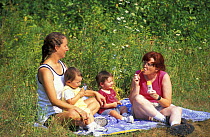 Mothers and children enjoying time in the sun near Meadow Pond, Stephenson's Way. Groveland, Massachusetts, USA