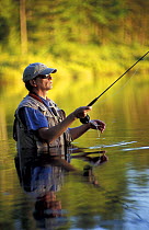 Man in hip-waders fly-fishing in Trout Pond, Freedom, New Hampshire, USA
