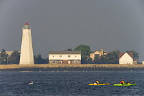 Fishing from sea kayaks in the mouth of the Connecticut River between Old Saybrook and Old Lyme, Connecticut, USA. Old Saybrook Lighthouse. Long Island Sound.
