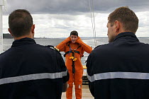 New passengers attend a survival suit demonstration on the quarter deck. BHO Beautemps-Beaupre, Iroise Sea, Briitany, France. August 2005.
