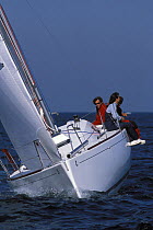 Beneteau First 27.7 heeling over, with crew sitting on upside rail. Off La Rochelle, France 2001.