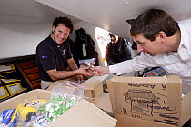 Crew members of "PRB", skippered by Vincent Riou, loading the boat with food and supplies before the start of the Vendee Globe 2008/2009, Les Sables d'Olonne, France. 7 November 2008.