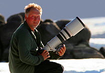 Photographer Ian McCarthy with camera waiting to photograph walruses, Ellesmere Island, Nunavut, Canada.