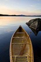 An empty canoe on the shoreline of Seboies Lake near Millincoket, Maine, USA.