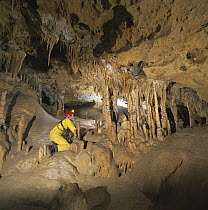 Potholer in cave examining stalactites and stalagmites, Cova Meravelles, Bloc del Cardo, Benifallet, Catalonia, Spain, 1996