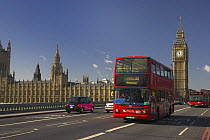 Double decker red bus crossing Westminster Bridge with Big Ben and the Houses of Parliament in the background, London, UK