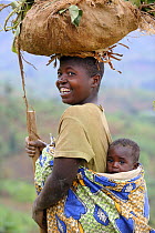 Woman with child carrying taro leaves on her head, Rwanda, Africa, 2008